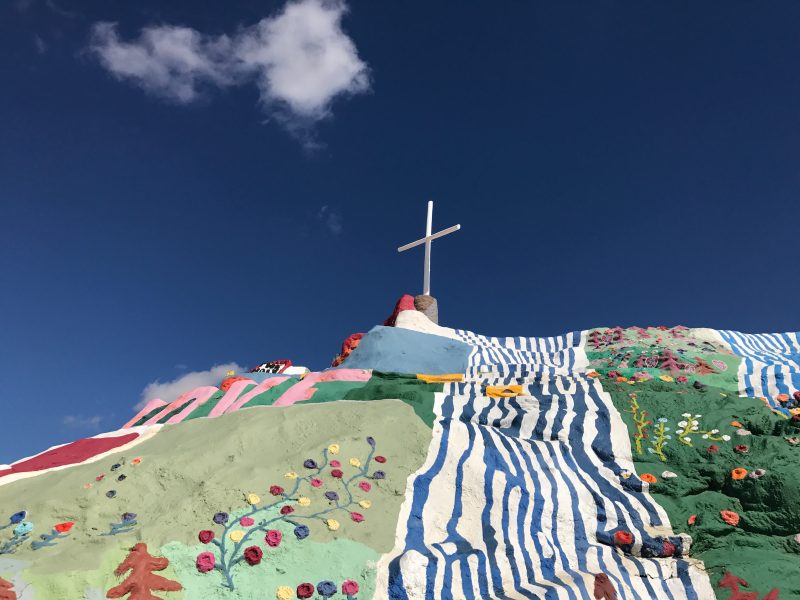 A closer photo of Salvation Mountain and the cross that tops it 