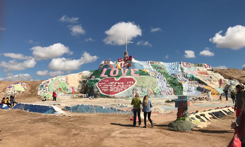 Tourists take in Salvation Mountain from afar and by walking on and through it 