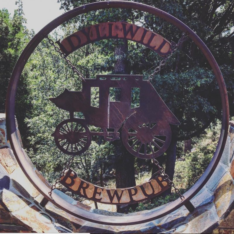 A sign showing a stagecoach at the entrance to the Idyllwild Brewpub