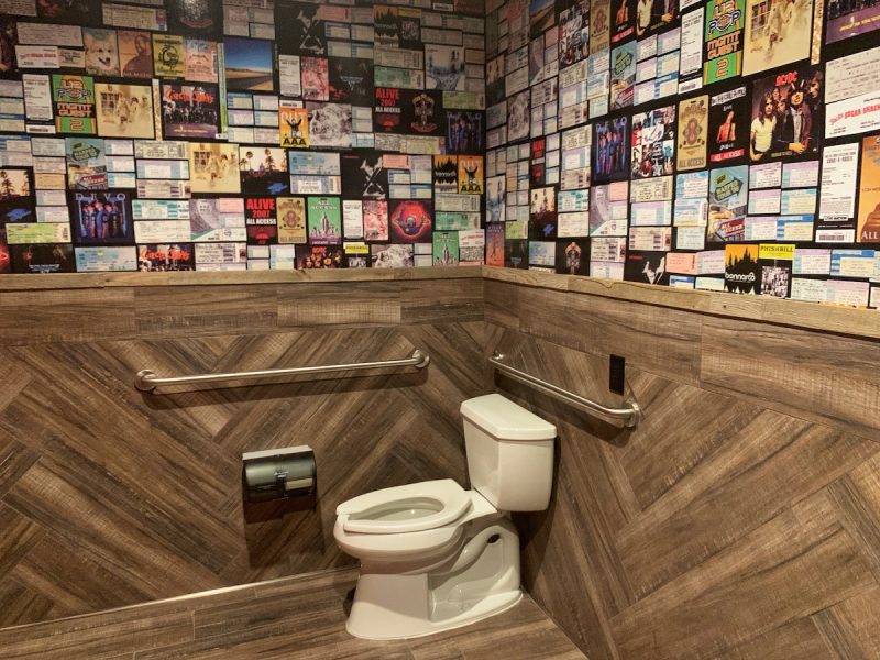The bathroom at Little Bar in Palm Desert is decorated with album covers and tickets