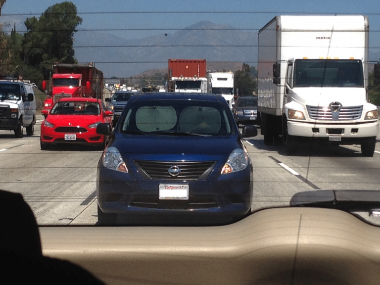 Good Grief.  Here is an Idiot Driving With Sun Shades in His Windshield on The 60