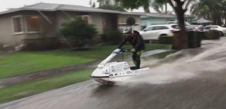 Move over guy floating on inflatable duck, this guy is jet skiing down a flooded road