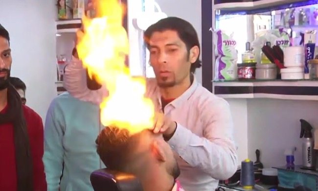 Would you let this barber style your hair with a blowtorch?