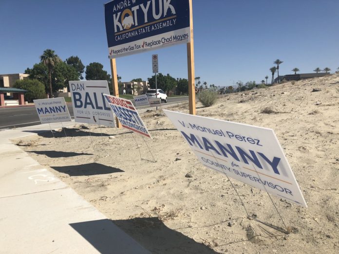 Political campaign signs seen littering Cook Street in Palm Desert, California