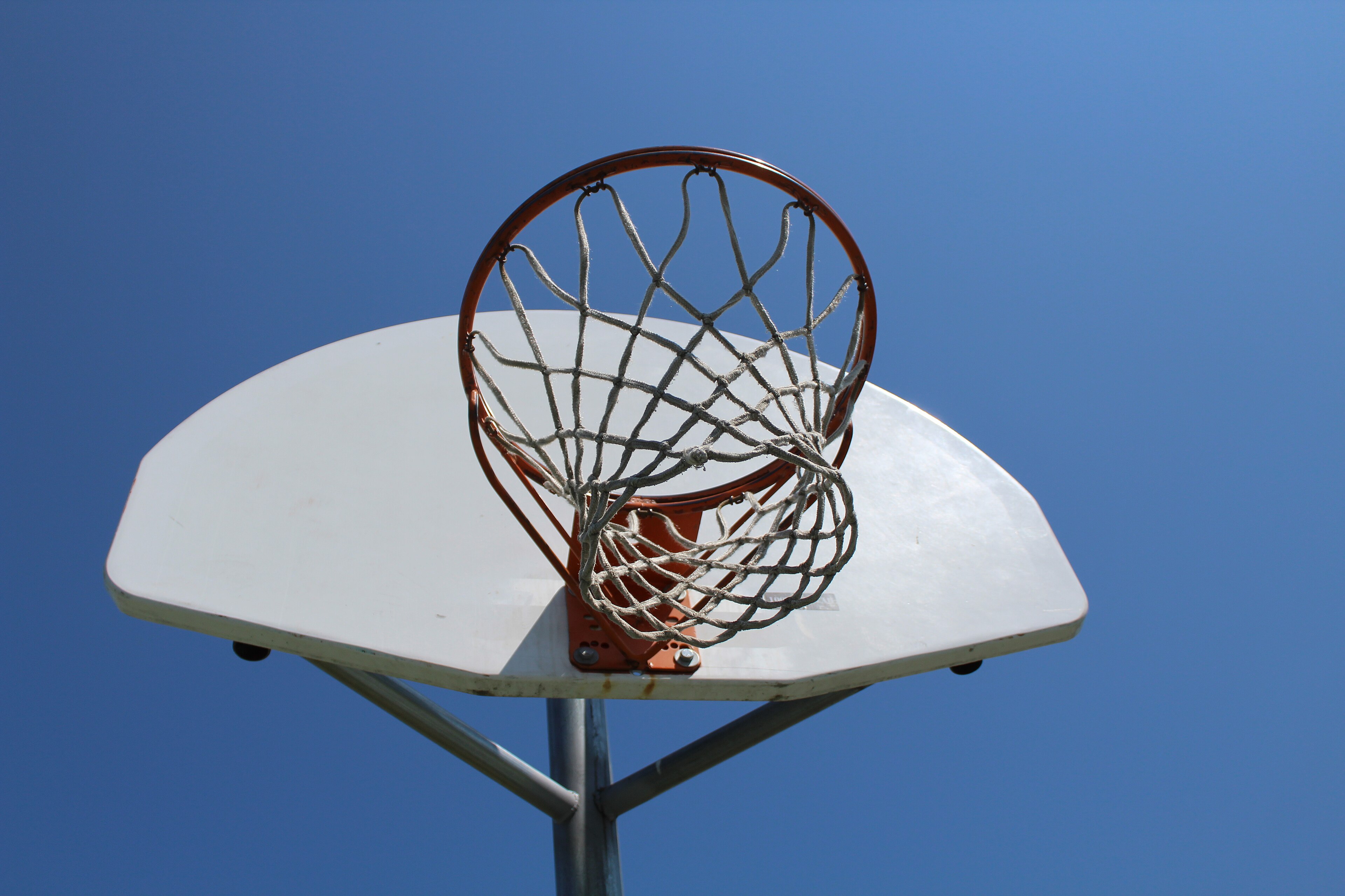 An angled view from below of a basketball hoop and net